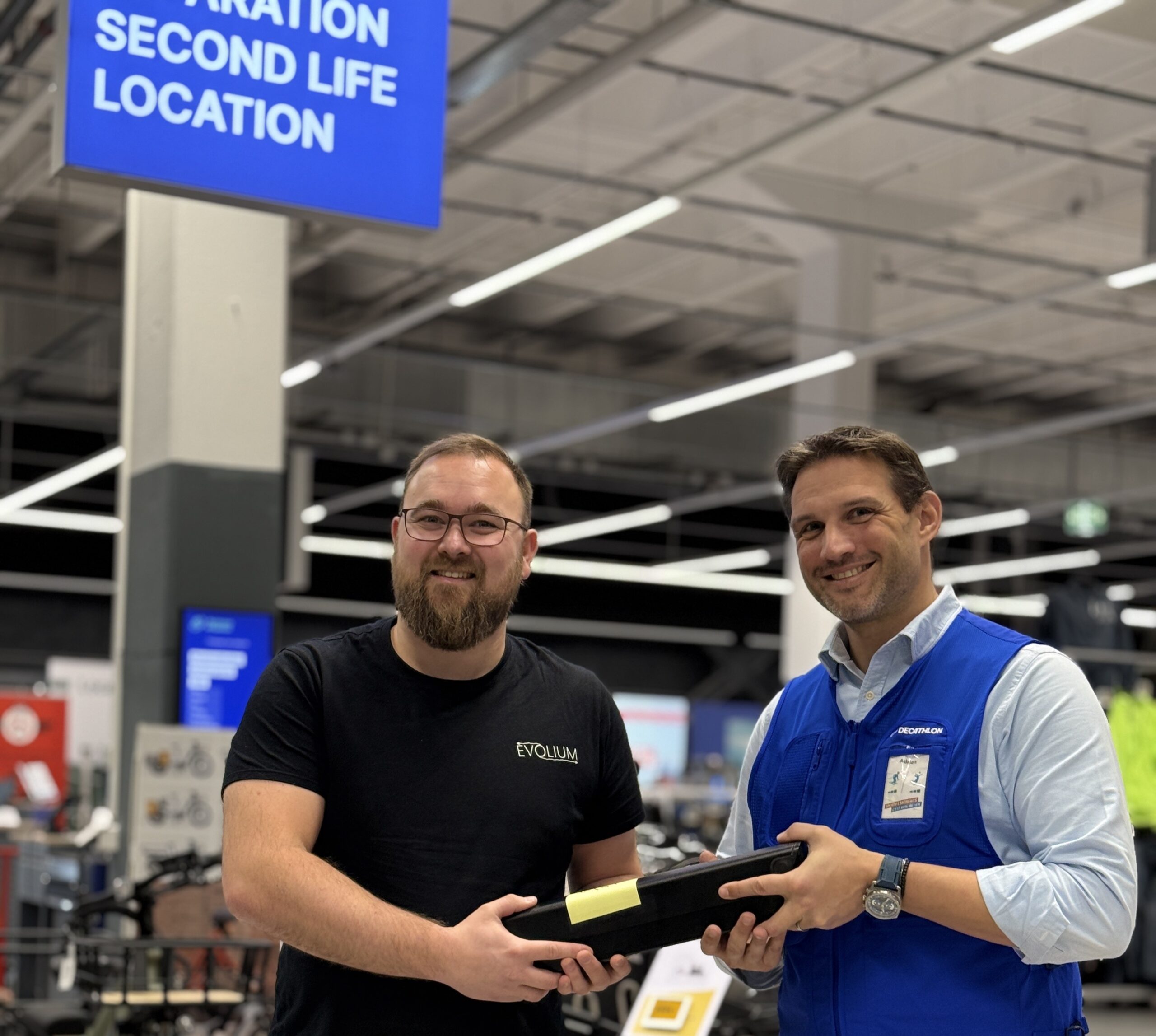 Decathlon x Evolium Picture of Adrien Lagache (Decathlon) giving a used e-bike battery to Alexandre Staub (Evolium)